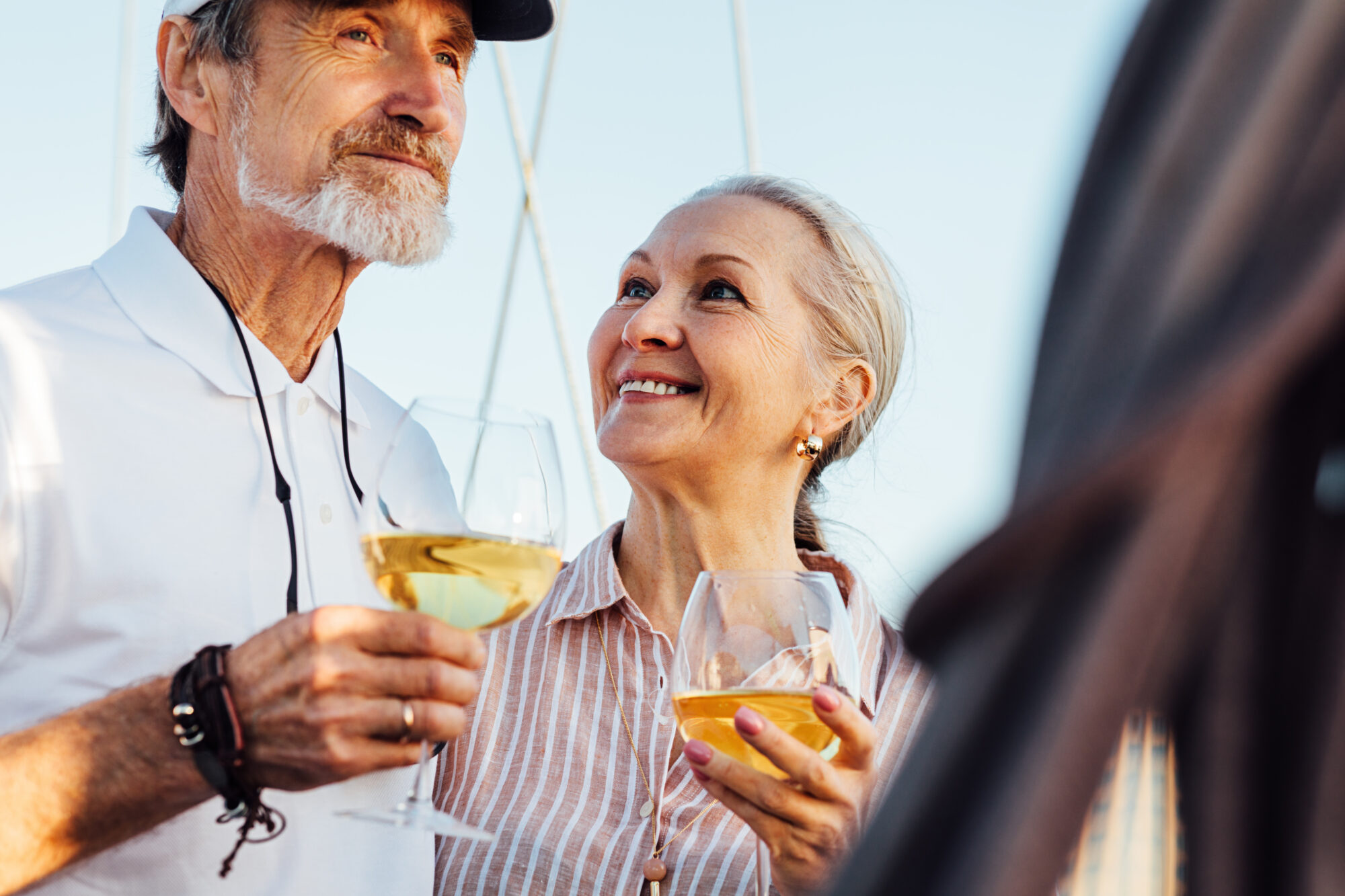 Pareja madura celebrando la vida a bordo de un catamarán de alquiler